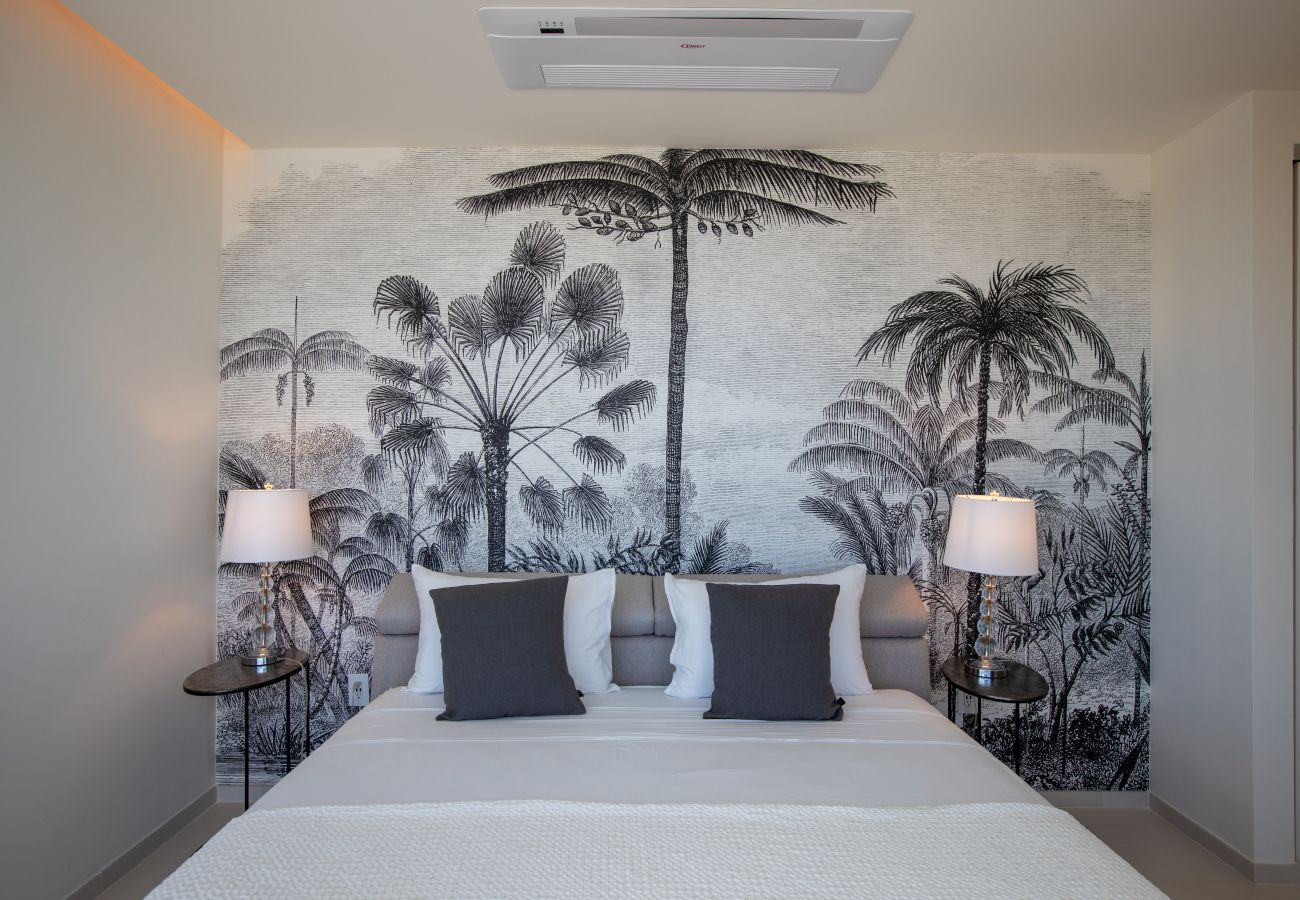 Grande chambre avec un lit confortable et une décoration tropicale