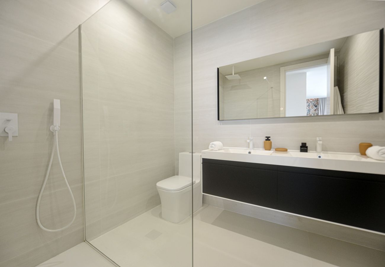 Belle salle de bain moderne avec armoires à double vasque et long miroir d'éclairage tactile